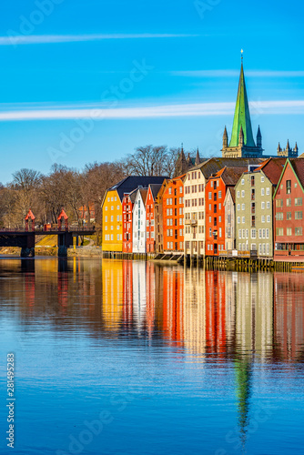 Fényképezés Nidaros cathedral and colorful timber houses surrounding river Nidelva in the Br