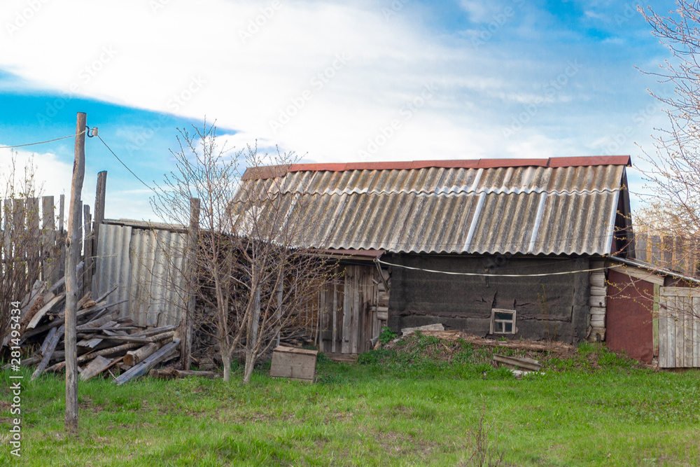 The old rickety wooden hut from logs with a roof covered with slate. Russian homemade country bath. The old rickety wooden hut from logs with a roof covered with slate. Russian homemade country bath.