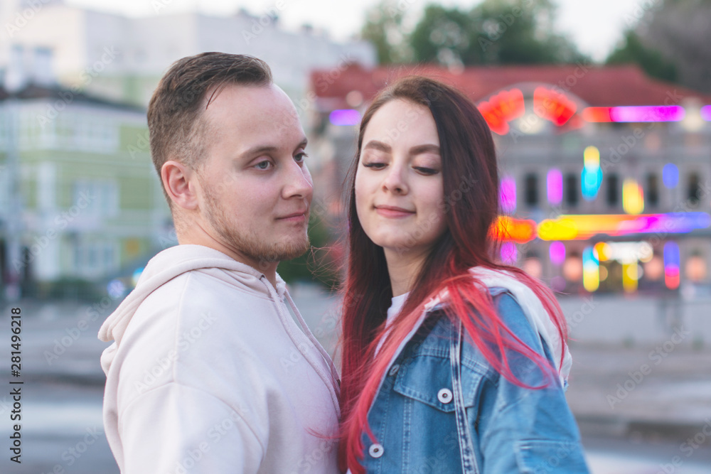 A happy loving young couple-a girl and a guy gently hugging on a Sunny summer day outside for a walk
