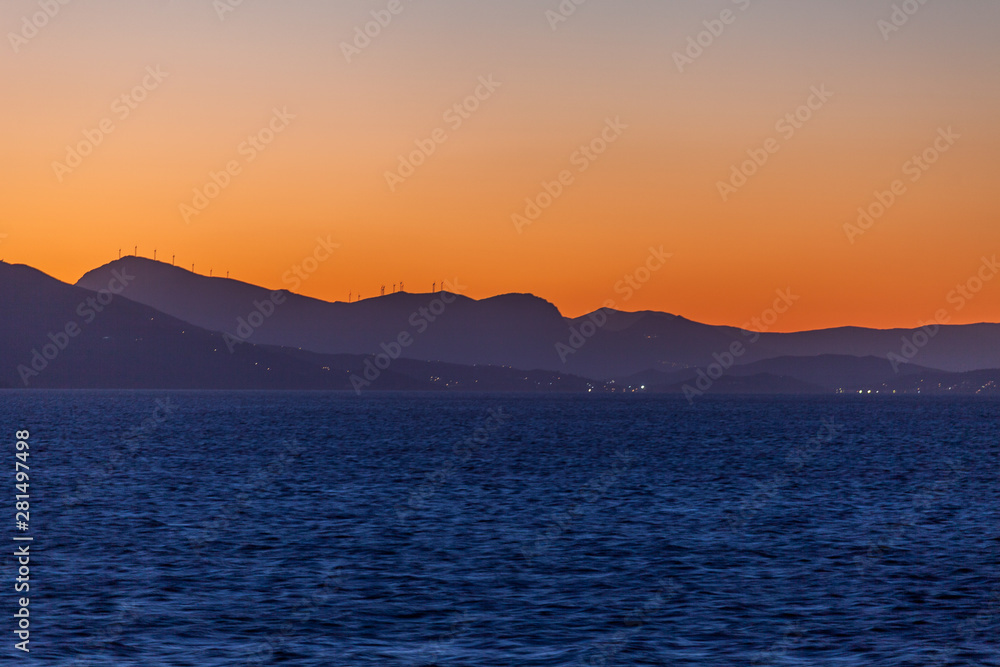 Aegean Sea islands silhouette with wind turbines at sunset Aegean Sea islands silhouette with wind turbines at sunset