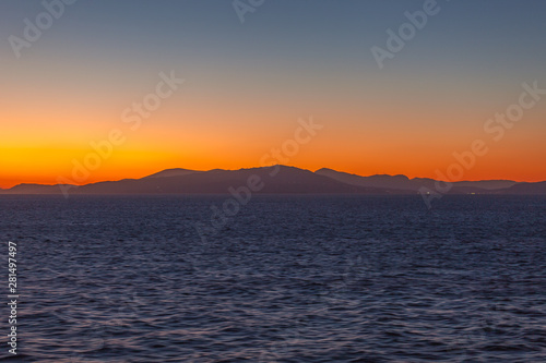 Beautiful sunset with orange sky with Aegean Sea islands background