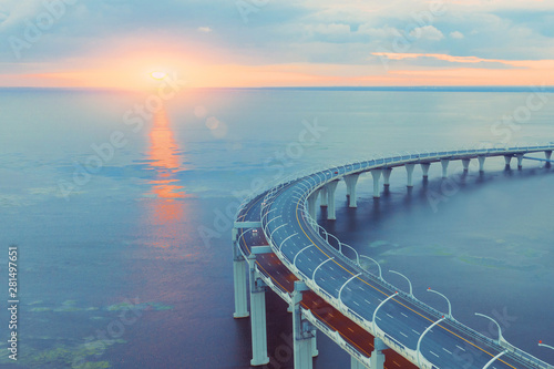 Aerial view of the highway junction viaduct turn over the bay in the evening at sunset.
