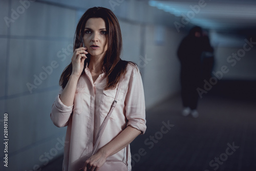 selective focus of woman talking on smartphone near thief in underpass © LIGHTFIELD STUDIOS