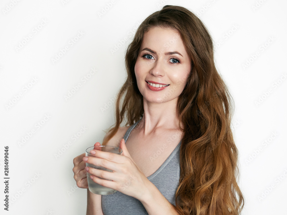 Young healthy beautiful blonde woman gorgeous long wavy hairstyle dressed grey sporty top having fun emotionally posing cold water misted mug on white background wall Young healthy beautiful blonde woman gorgeous long wavy hairstyle dressed grey sporty top having fun emotionally posing cold water misted mug on white background wall