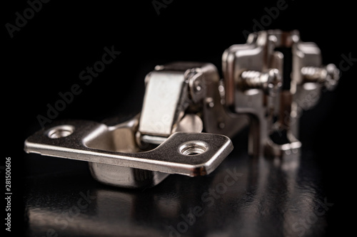 Metal furniture hinges with hydraulic brake. Furniture accessories for the production of furniture on a dark table.