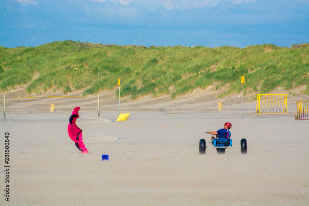 Off-road driving wind buggy on sandy beach with green sandy dunes Off-road driving wind buggy on sandy beach with green sandy dunes