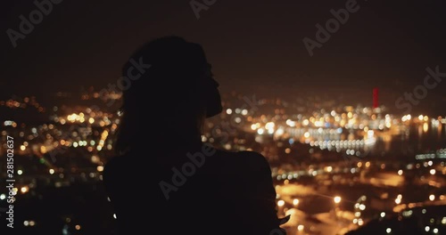 Female silhouette standing in front of beautiful night seatown panorama. Back view of inspired girl observing amazing cityscape of La Spezia. Liguria, Italian summer destination. photo