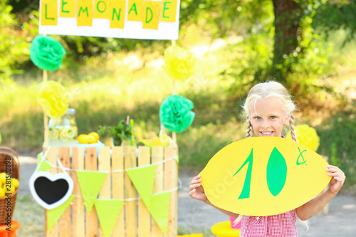 Cute little girl selling lemonade in park