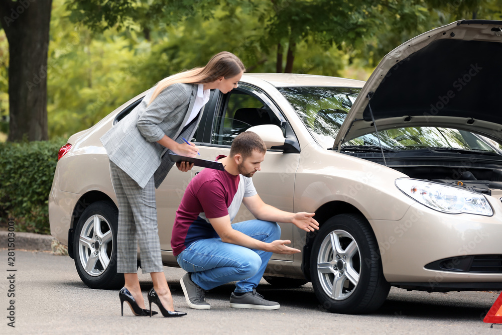Young man and insurance agent near damaged car outdoors