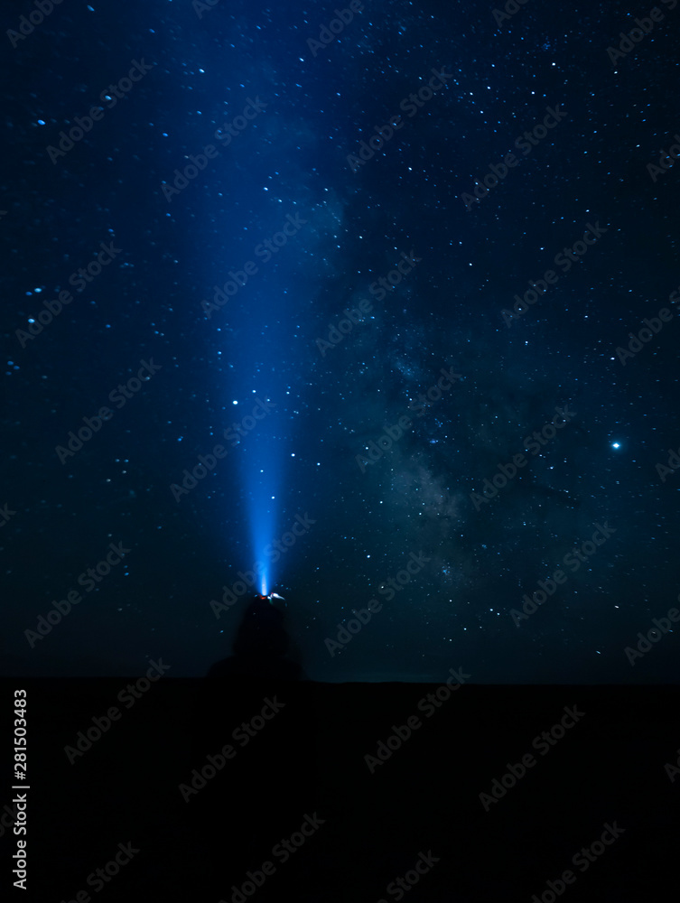 A silhouette pointing a head-light on  the Milky Way direction - Gobi Desert, Mongolia
