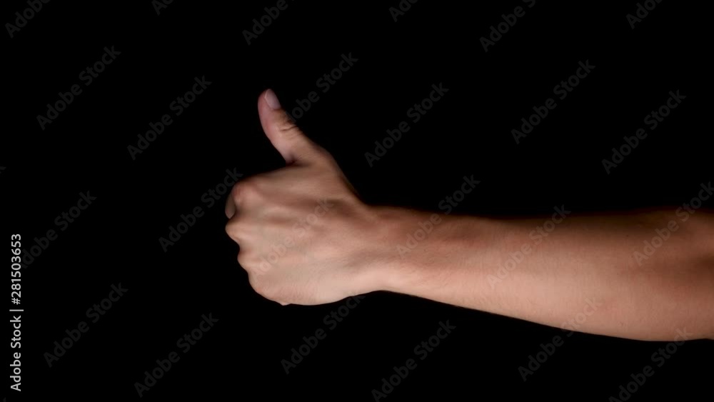 Close-up view of a male hand pushing in from the right and indicating his acceptance with a thumbs up (ok) gesture Close-up view of a male hand pushing in from the right and indicating his acceptance with a thumbs up (ok) gesture