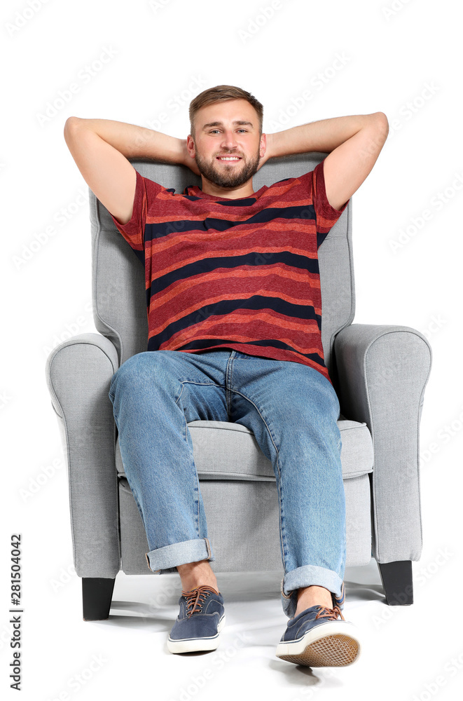Obraz premium Handsome young man relaxing in armchair against white background