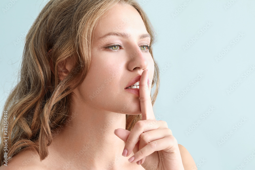 Beautiful young woman showing silence gesture on color background Beautiful young woman showing silence gesture on color background