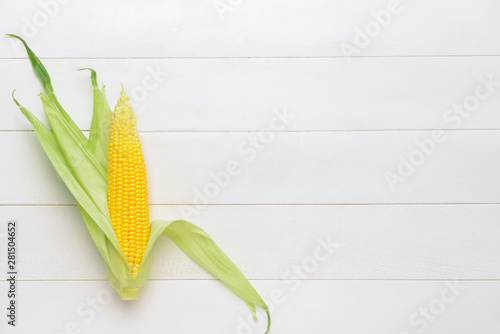 Fresh corn cob on white wooden background