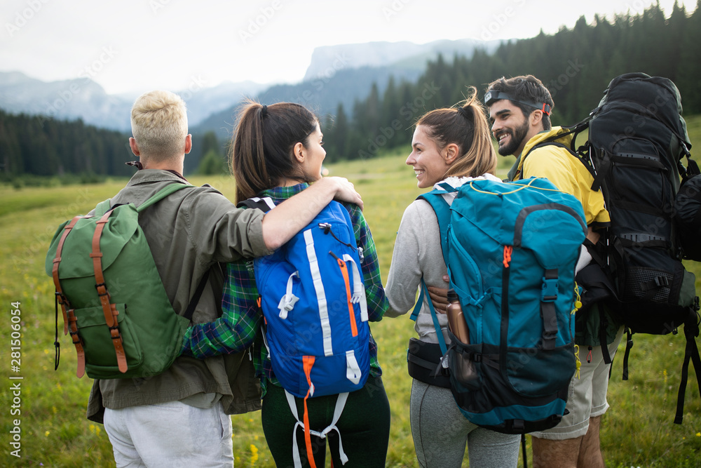 Hiking with friends is so fun. Group of young people with backpacks walking together Hiking with friends is so fun. Group of young people with backpacks walking together