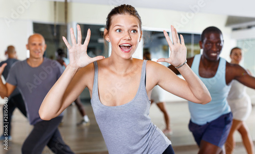 Cheerful people practicing vigorous lindy hop movements in dance class