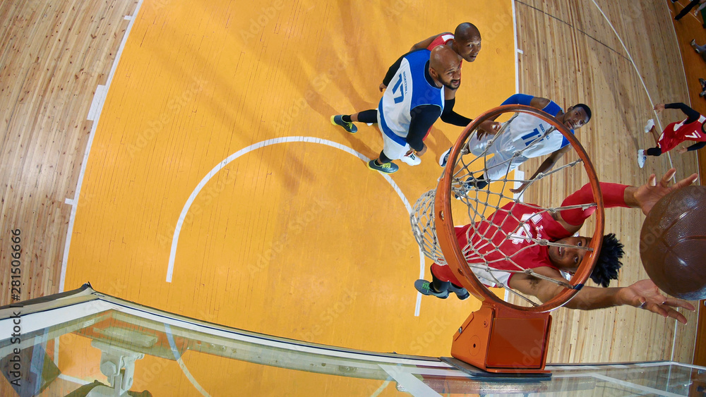 Professional basketball player in action performing slam dunk in a basketball hoop on a sports arena. View from above the hoop. Professional basketball player in action performing slam dunk in a basketball hoop on a sports arena. View from above the hoop.