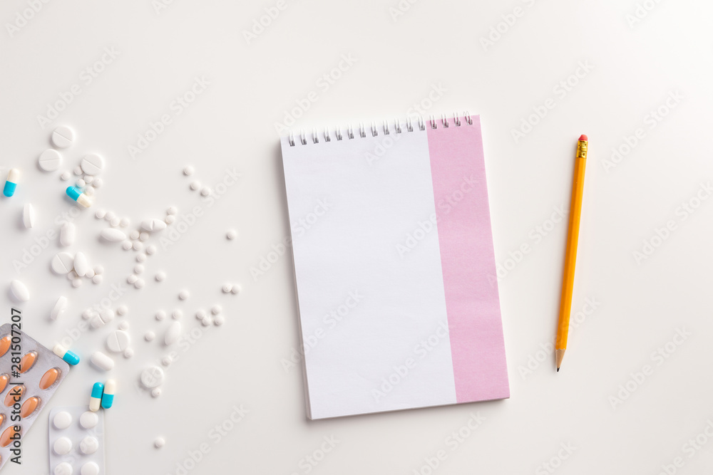 Pills, pencil and notebook on white background. Medical concept. Flat lay. Pills, pencil and notebook on white background. Medical concept. Flat lay.