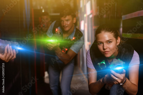 Young female with laser gun took aim and having fun with friend