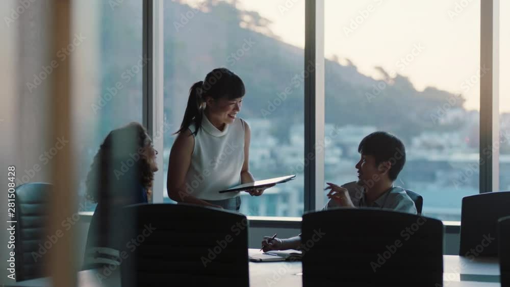 business people working late asian team leader woman meeting with colleagues discussing project manager sharing ideas on tablet computer group of executives brainstorming in office at sunset