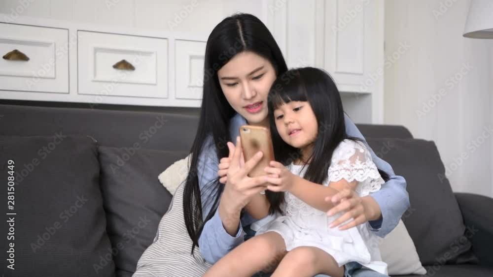Family concept. Mother and daughter are taking pictures in the living room. Family concept. Mother and daughter are taking pictures in the living room.