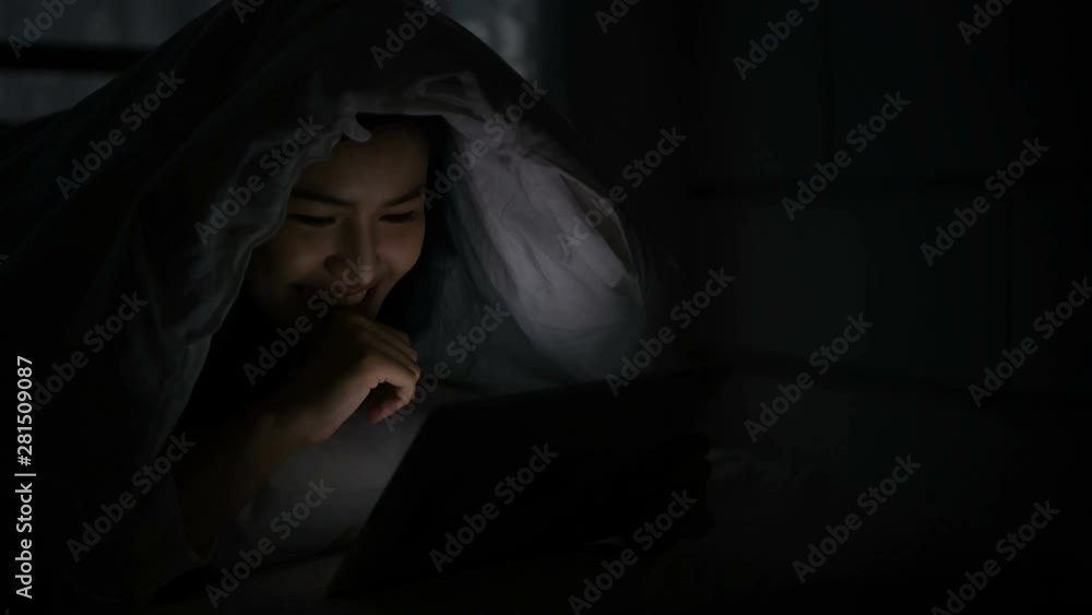 Communication concept. Women are playing tablets in the bedroom at night. Communication concept. Women are playing tablets in the bedroom at night.
