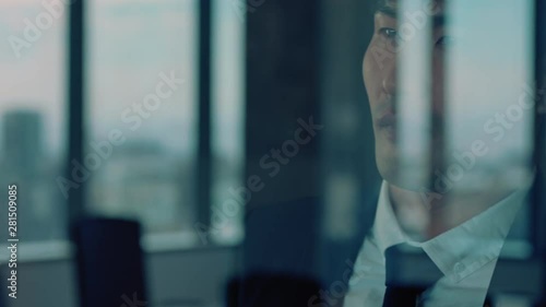 successful asian businessman looking out window proud ceo planning ahead thinking of ideas for future investment strategy corporate manager enjoying leadership career in office photo