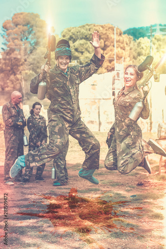smiling young man and woman in full paintball gear having fun af