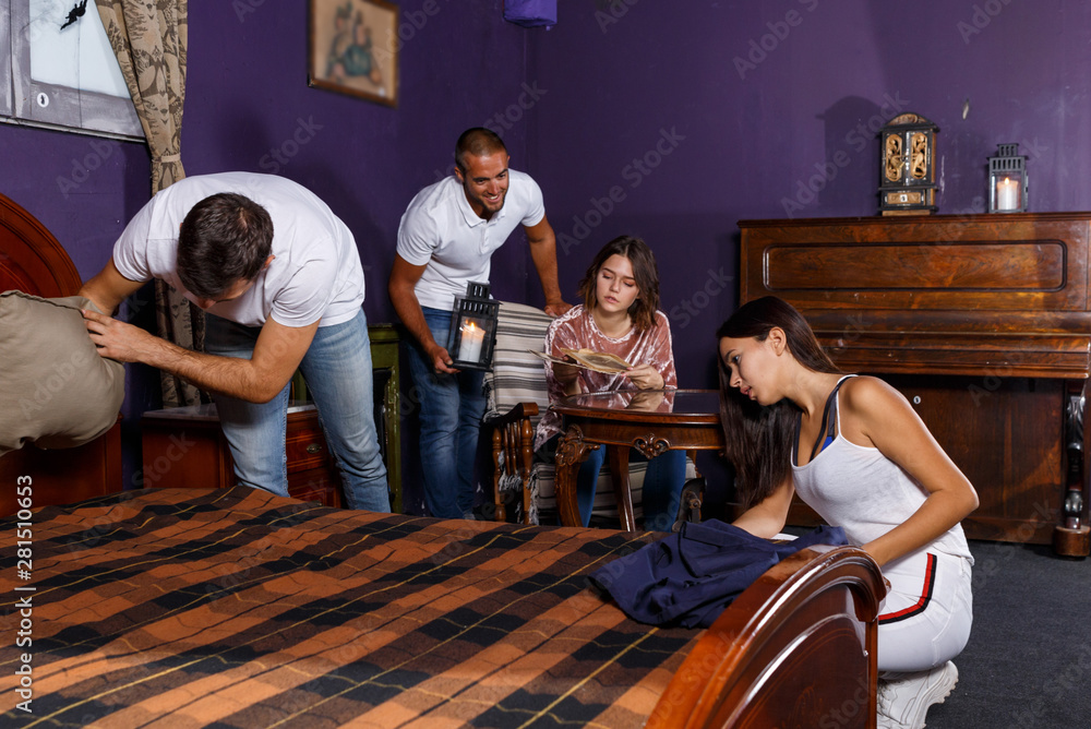 Young adults in escape room with antique furnitures