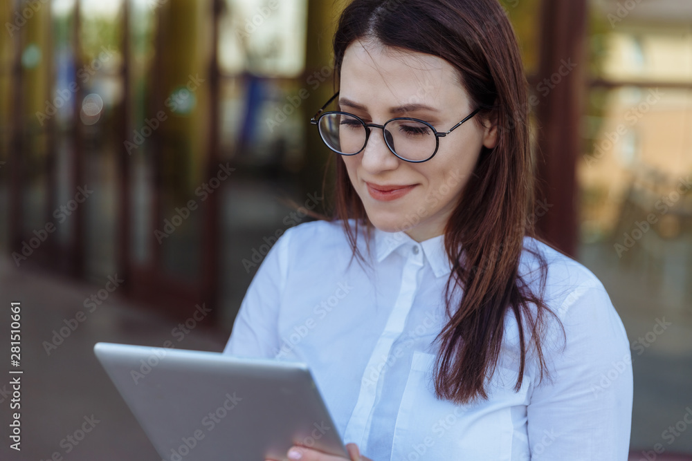Portrait of smiling business woman using tablet pc in front of office building. Portrait of smiling business woman using tablet pc in front of office building.