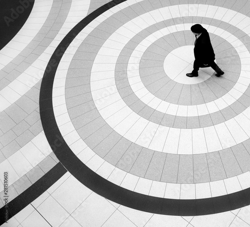 High angle view of man in coat and hat walking on tiled floor