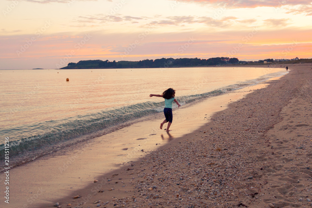 Young girl going away on sunset sea background.