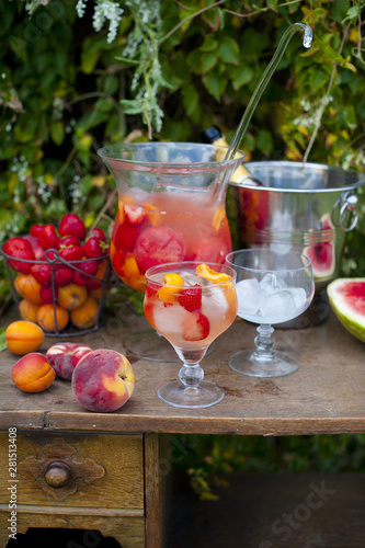 fruit cruchon cocktail punch in jug and glasses with ice and fruit photo