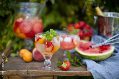 fruit cruchon cocktail punch in jug and glasses with ice and fruit photo