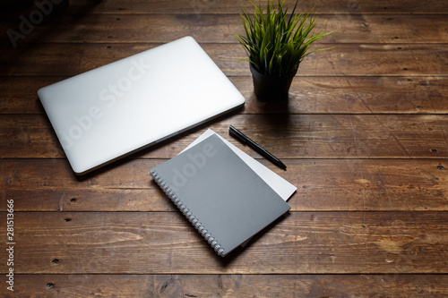 work space of a businessman. view from above . coffee black note and laptop on the desktop with black note. laptop on wooden background