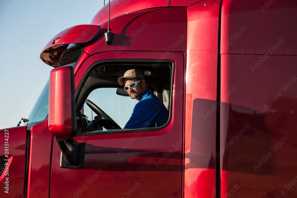 Man wearing sunglasses sitting in commercial truck Man wearing sunglasses sitting in commercial truck