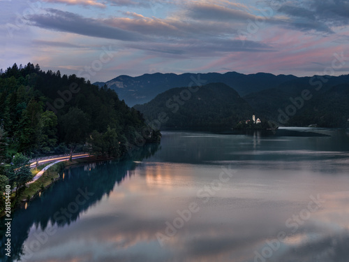 Sunrise view of Lake Bled in Slovenia with Pilgrimage Church of Assumption of Mary and car trails on street