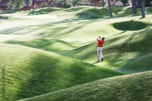 Rear view of golfer playing golf on golf course