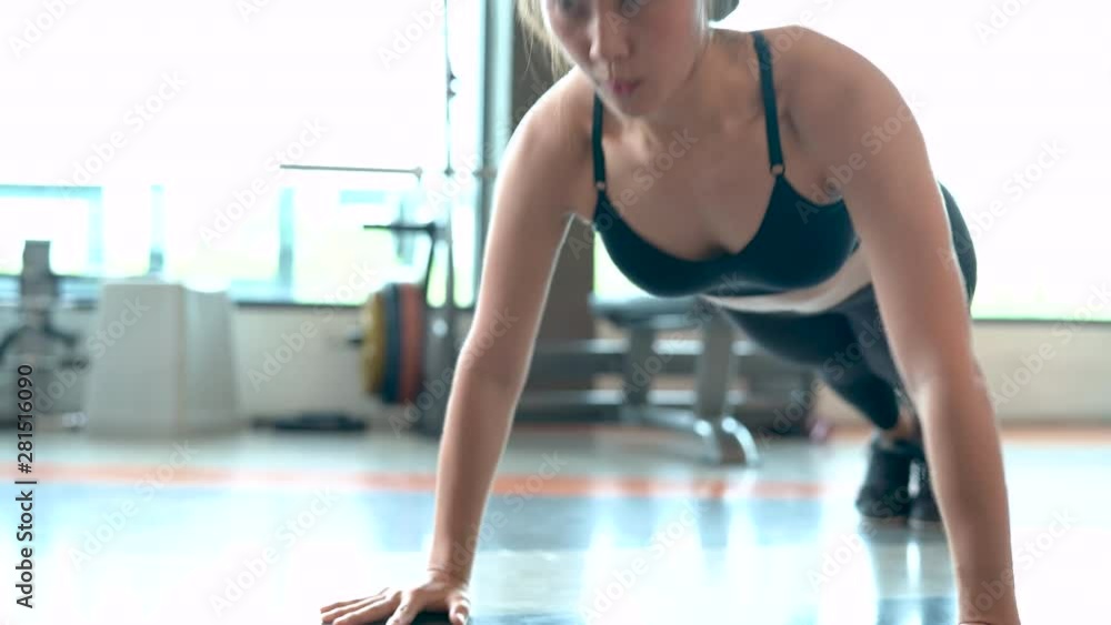 Professional beautiful asian woman workout doing push up exercise in the fitness gym healthy lifestyle, athlete muscle building strong and fit body 4k resolution.