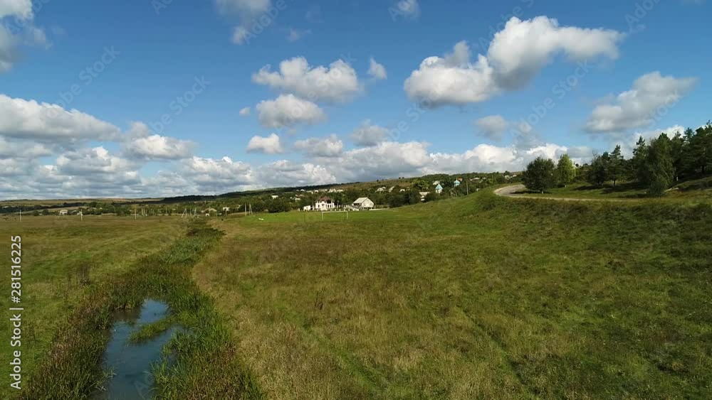 A river outside the village near the road, filmed with a drone.