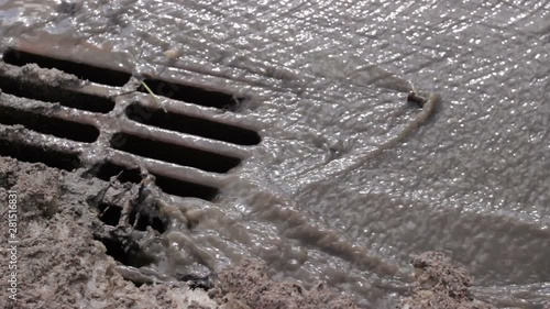 Melted water flows down through the manhole cover photo