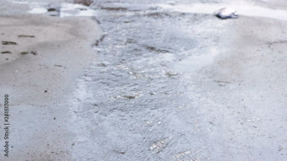 Water flows from the melting snow along the asphalt. Water flows from the melting snow along the asphalt.