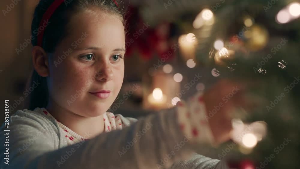 happy little girl decorating christmas tree with beautiful ornaments and baubles enjoying festive decorations at home on calm winter evening 4k footage happy little girl decorating christmas tree with beautiful ornaments and baubles enjoying festive decorations at home on calm winter evening 4k footage