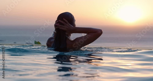 travel woman swimming in pool at luxury hotel spa with beautiful sunset view of ocean mediterranean travel holiday resort relaxing lifestyle freedom 4k photo