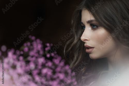 Beautiful brunette girl with a bouquet of flowers close-up