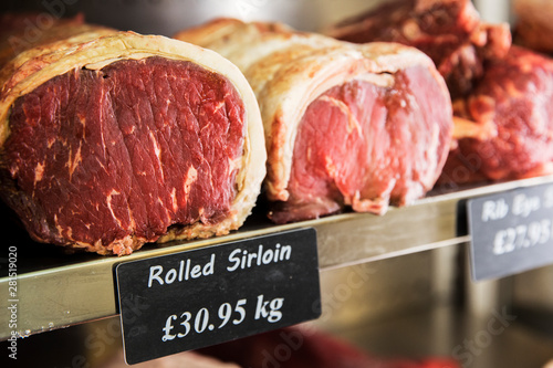 Close up of piece of rolled beef sirloin meat on metal shelf photo