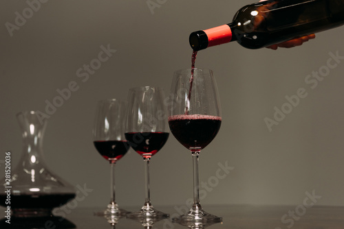 partial view of man pouring wine in wine glasses in restaurant