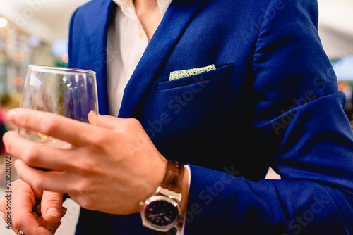 An elegant businessman holds a glass of wine during a business meeting.