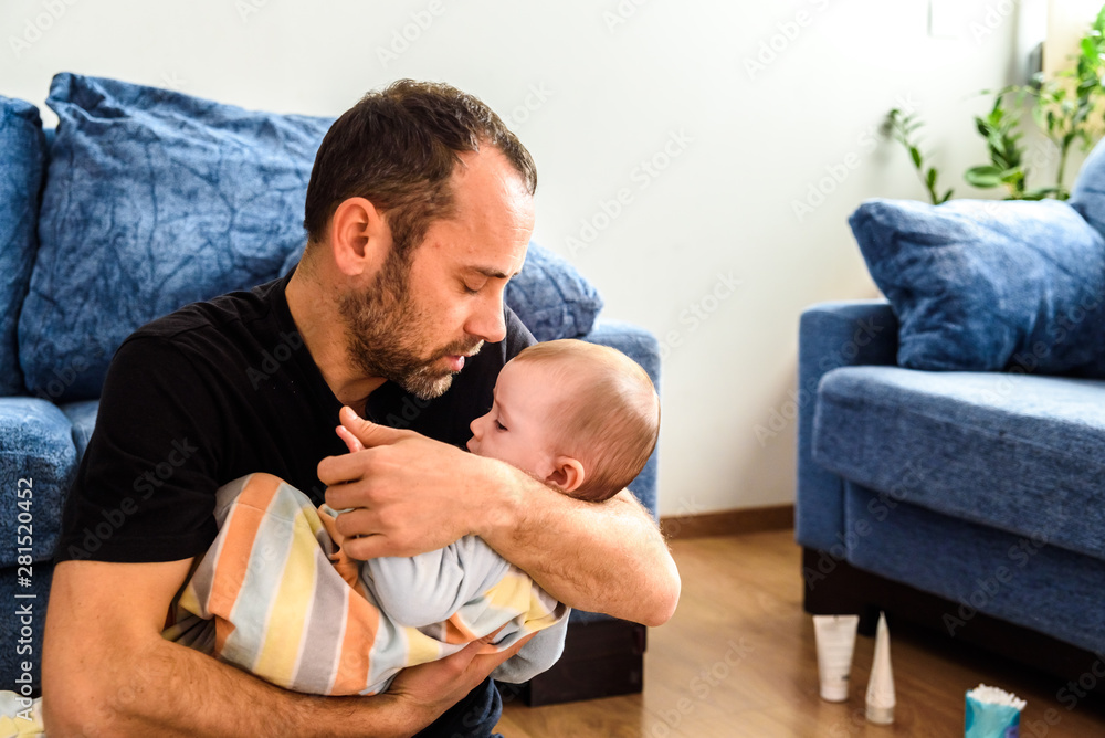 Fototapeta premium Dad hugging his baby daughter lovingly.