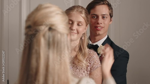 teenage couple prom night teens posing for photo with proud mom photographing teenagers for homecoming dance wearing stylish fashion excited for glamorous event 4k